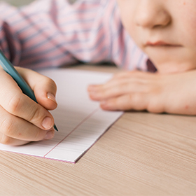 Boy writing in notebook